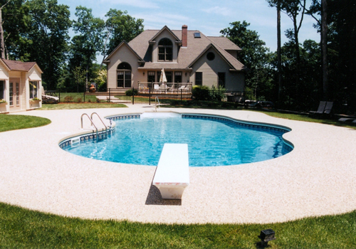 20' x 40' Oasis with an exposed aggregate cantilever deck by Blue Dolphin Pools & Spas