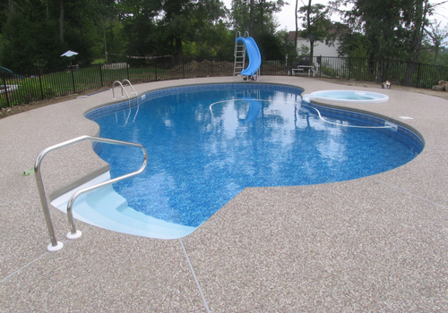 0' x 40' Oasis with an exposed aggregate cantilever deck by Blue Dolphin Pools & Spas