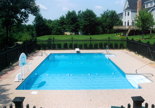 20' x 40' Rectangular with an exposed aggregate cantilever deck by Blue Dolphin Pools & Spas