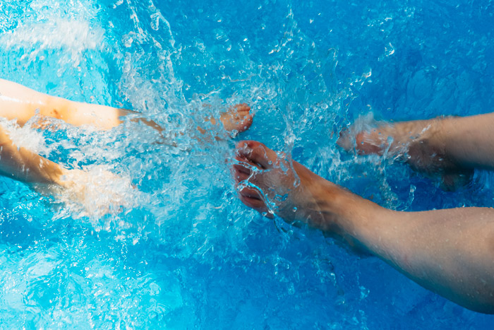 People kicking their feet in the pool